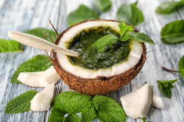 Wall Mural - Half of coconut with chutney mint sauce on table