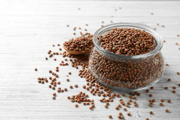 Glass jar with brown lentils on wooden table