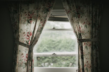 Dark Shadowy Room Looking Outside Window With Vintage Floral Curtains