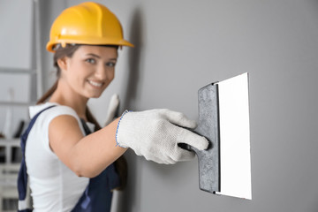 Sticker - Young female decorator working with spatula indoors