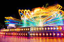 Long Exposure Shot Of Carousel Attraction In A Fair At Night With Colorful Lights