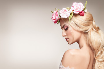 Beautiful woman portrait with long blonde hair and flowers on head. Tender bride. 