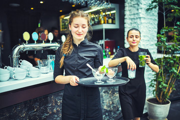 Waiters carrying plates with food, in a restaurant.