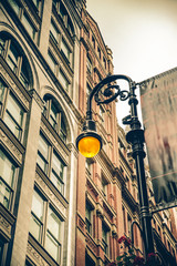 Wall Mural - Vintage style illuminated streetlamp with New York City apartment buildings in the background.