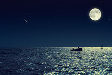 Scenic View Of Small Fishing Boat In Calm Sea Water At Night And Full Moon