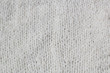 © dashtik - Sweater or scarf Pattern Of White Knitted Fabric Texture Background