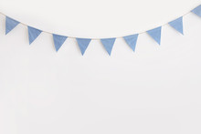 Blue And White Striped Bunting Hanging Against A White Wall