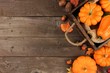 Autumn side arrangement of leaves and a crate of pumpkins over a rustic wood background