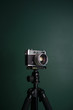 © BrkatiKrokodil/Stocksy - Retro camera on a tripod against green background