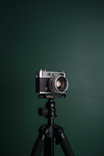 Retro Camera On A Tripod Against Green Background