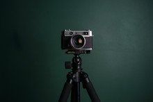 Retro Camera On A Tripod Against Green Background