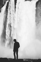 Silhouette Of Man Standing By Waterfall