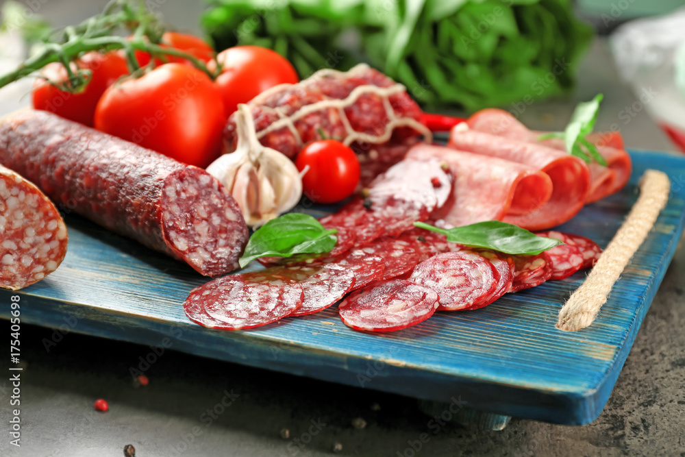 Delicious sliced sausages on wooden board