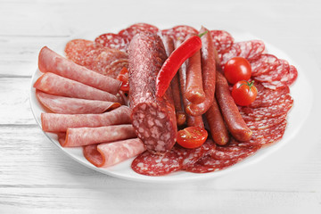 Poster - Plate with delicious sliced sausages on wooden table