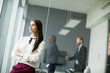 © BGStock72 - Modern businesswoman standing in modern office with young business people in the background