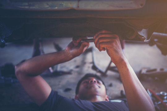 technician working on checking and service car in  workshop garage; technician repair and maintenance engine of automobile in car service