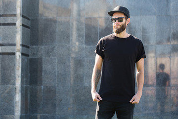 hipster handsome male model with beard wearing black blank t-shirt with space for your logo or desig