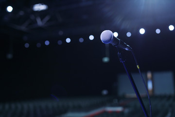 Wall Mural - microphone in concert hall or conference room with cold lights in background.