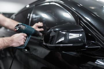 Wall Mural - car tinting - worker applying tinting foil on car window.