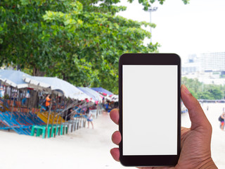 man hand using smart phone at beach background..