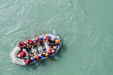 Top View Of The Boat With People Rafting Along The Mountain River