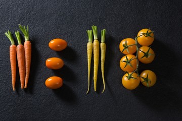 Carrots and tomatoes on black background