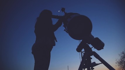 Wall Mural - girl looking at the moon through a telescope.