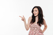 © Drobot Dean - Portrait of an excited brunette woman in dress pointing finger