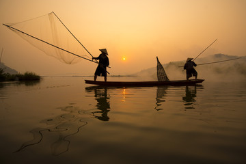 Two fishermen are fishing on the boat at Mekong river in the morning in Nong Khai, Thailand