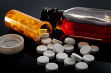 Opioid Epidemic, Drug Abuse And Dangerous Mixing Of Barbiturates And Alcohol Concept With Oxycodone Pills Fallen Out Of A Prescription Pill Bottle Next To A Flask Of Hard Liquor