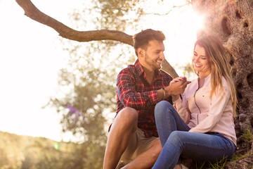 Young beautiful couple under tree in beautiful nature.