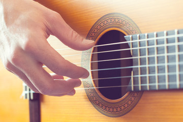 Man's hands playing on guitar