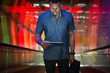 © Jelena Jojic Tomic/Stocksy - Man looks down on his tablet while standing at the elevator