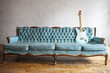 © Lisa MacIntosh/Stocksy - vintage blue couch with vintage blue guitar