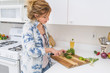 © SKC/Stocksy - Woman Chops Fresh Herbs and Onions in the Kitchen