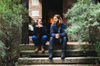 © BONNINSTUDIO/Stocksy - Young couple sitting on the stairs in front of the rural house.