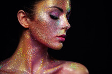 Portrait Of Beautiful Woman With Sparkles On Her Face. Girl With Art Make-Up In Color Light. Fashion Model With Colorful Makeup