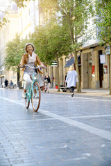 Wall Mural - Senior woman riding city bike in town