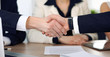 © rogerphoto - Close up of business people shaking hands at meeting or negotiation in the office. Partners are satisfied because signing contract