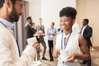 © Syda Productions - business people with conference badges and coffee