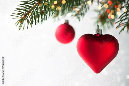 Plakat Czerwoni boże narodzenie ornamenty, serce i piłka, na xmas drzewie na błyskotliwości bokeh tle z migotaniem zaświecają. Wesołych kartki świąteczne. Motyw zimowy. Szczęśliwego Nowego Roku.