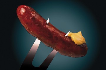 Wall Mural - Grilled beef sausage with mustard on a meat fork