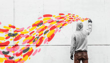 Street Artist Drawing With Spray Can On Wall