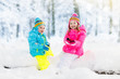 © famveldman - Kids playing in snow. Children play outdoors in winter snowfall.