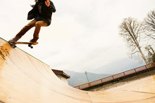 A Guy Skateboarder Skating On A Wet Ramp Doing Tricks In The Mountains