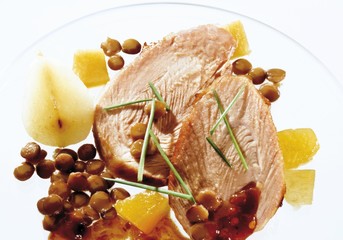 Wall Mural - Two slices of roast pork with pears and lentils on a glass plate