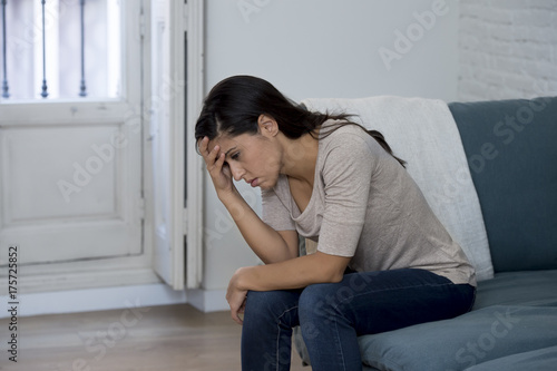 Zdjęcie XXL Łacińska kobieta leżącego w domu siedzi na kanapie płacz zmartwiony cierpienia depresji czuje się smutny