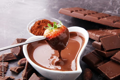 Plakat Fondue z topiącą się czekoladą lub roztopioną czekoladą i truskawkami.