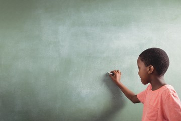 Wall Mural - Schoolboy writing on chalkboard