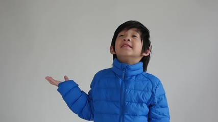 Wall Mural - Happy asian child in  blue winter clothes standing slow motion 